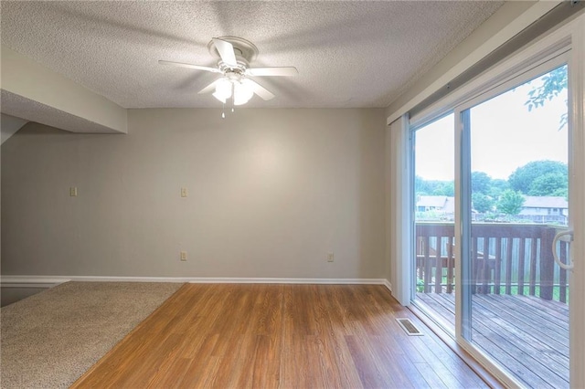 spare room featuring wood-type flooring, a textured ceiling, and ceiling fan