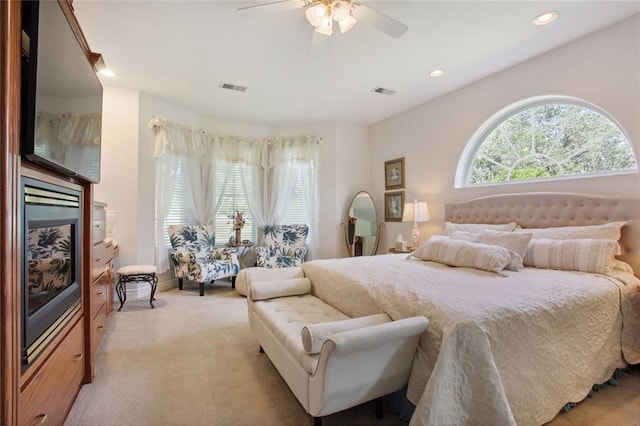 bedroom with light colored carpet, visible vents, recessed lighting, and multiple windows