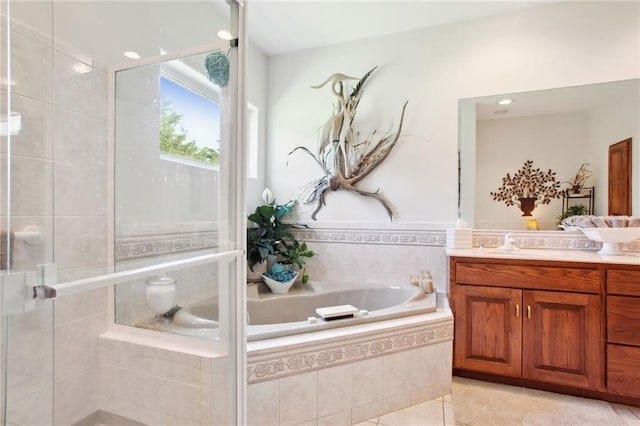 bathroom featuring tile patterned floors, vanity, and shower with separate bathtub