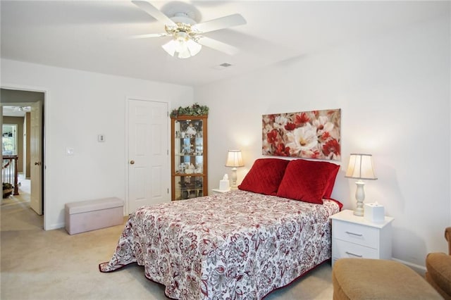 bedroom with visible vents, a ceiling fan, and light colored carpet