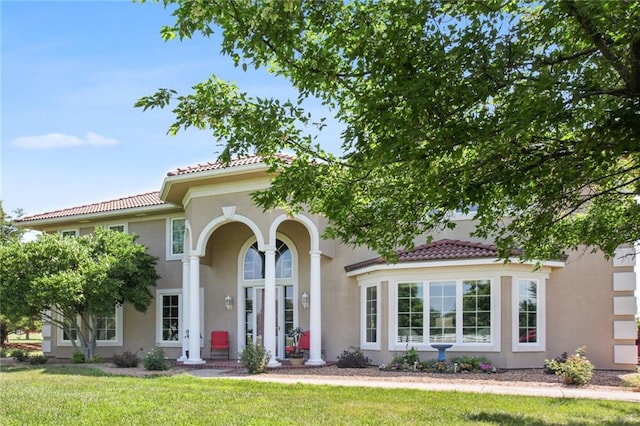 mediterranean / spanish-style house featuring a front lawn