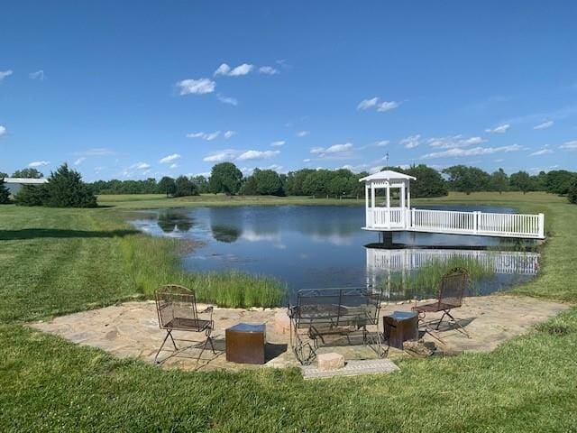 dock area featuring a gazebo, a yard, a water view, and a fire pit