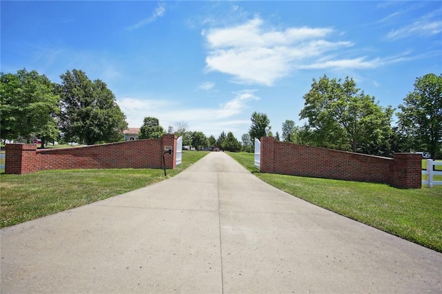 view of gate with a yard