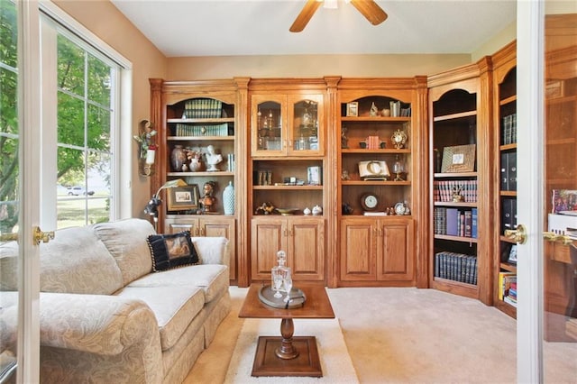 living area with ceiling fan and light carpet