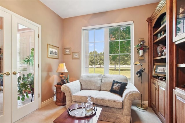 living room with french doors, light carpet, and baseboards