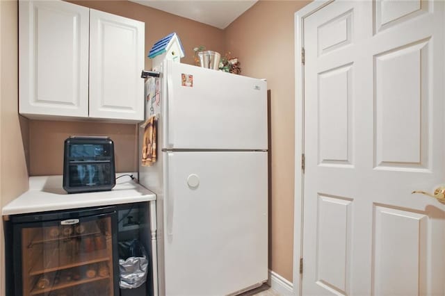 kitchen with wine cooler, white cabinets, and white refrigerator