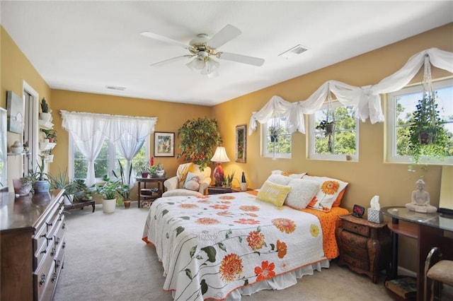 bedroom featuring ceiling fan, multiple windows, visible vents, and carpet flooring