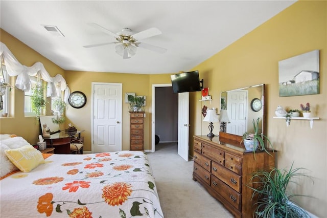 bedroom with light carpet, ceiling fan, and visible vents