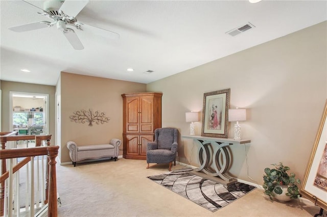 living area featuring ceiling fan and light colored carpet