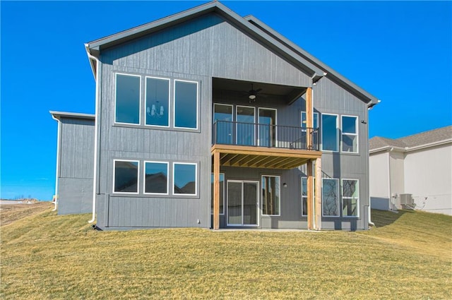 rear view of property featuring central AC, ceiling fan, a yard, and a balcony