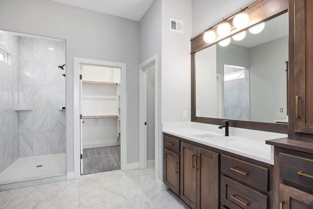 bathroom with vanity and a tile shower