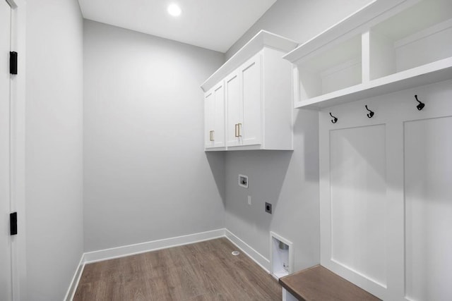 clothes washing area with hookup for an electric dryer, cabinets, hardwood / wood-style flooring, and washer hookup