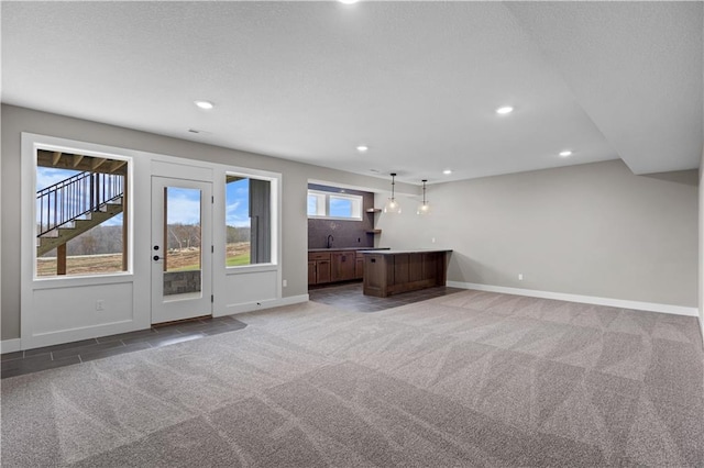 unfurnished living room with carpet floors and wet bar