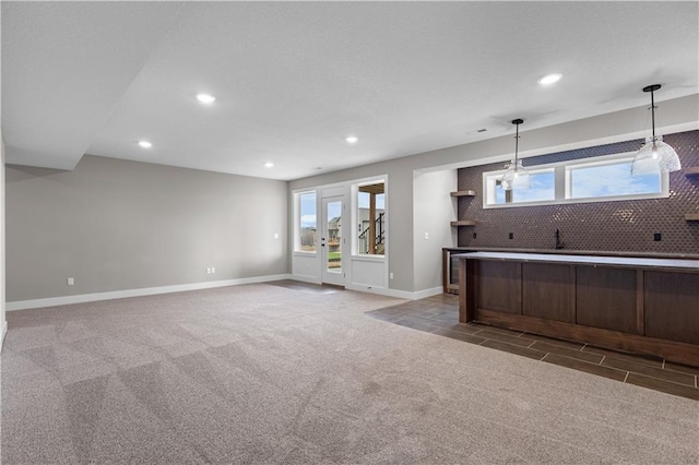 kitchen featuring decorative light fixtures and carpet floors