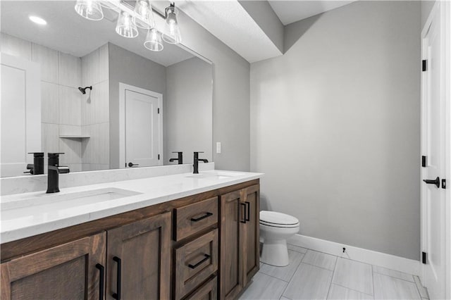 bathroom featuring a shower, vanity, and toilet