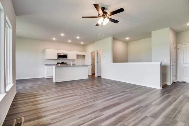 unfurnished living room with hardwood / wood-style flooring and ceiling fan