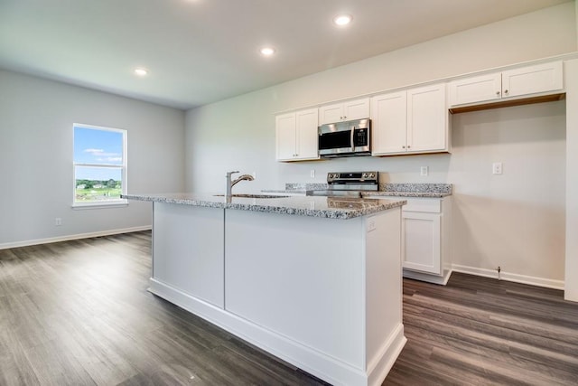 kitchen with white cabinets, appliances with stainless steel finishes, and a center island with sink