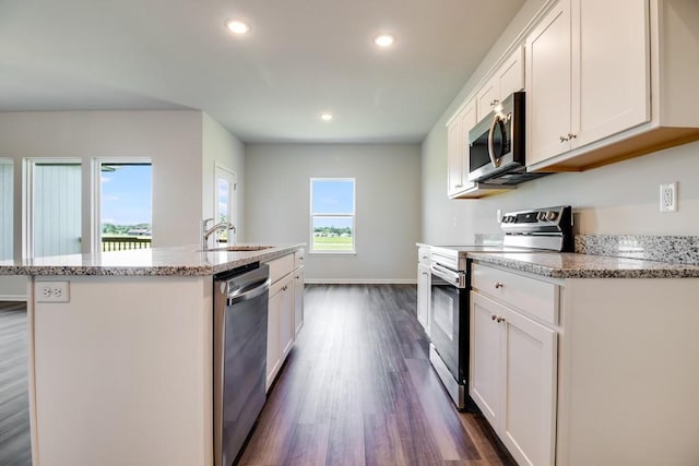 kitchen with an island with sink, sink, white cabinets, and stainless steel appliances