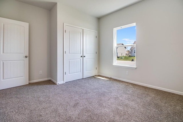 unfurnished bedroom featuring carpet flooring and a closet