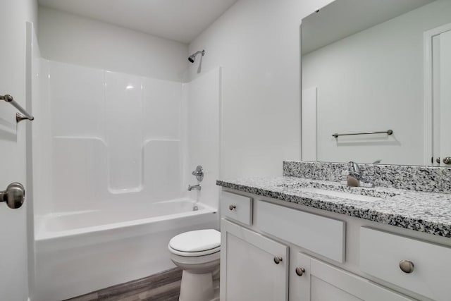 full bathroom with hardwood / wood-style flooring, vanity, bathtub / shower combination, and toilet