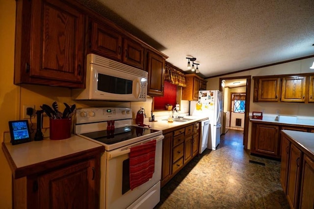 kitchen featuring sink, white appliances, a textured ceiling, and vaulted ceiling