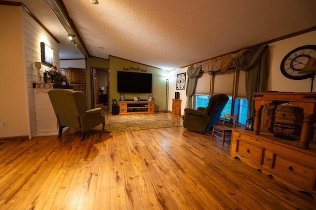 living room featuring light wood-type flooring, a textured ceiling, and lofted ceiling