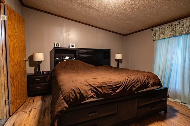 bedroom featuring a textured ceiling, ornamental molding, and light wood-type flooring