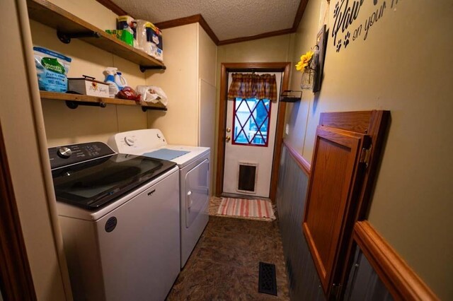 washroom with a textured ceiling, crown molding, and independent washer and dryer