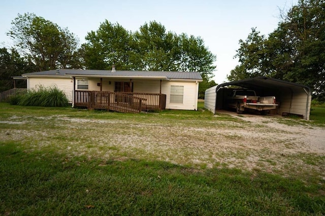 back of property featuring a deck, a carport, and a lawn