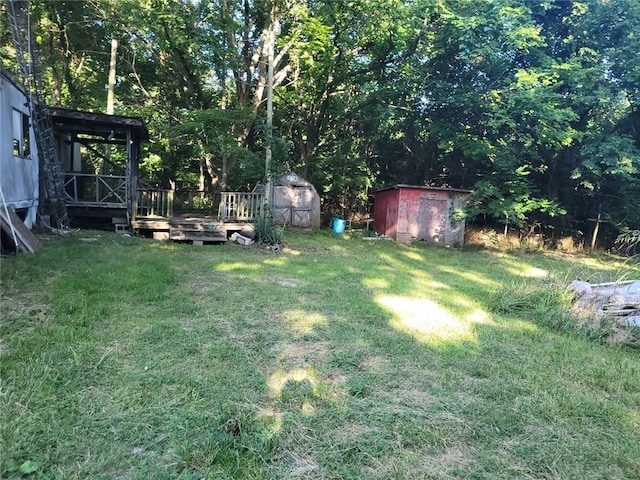 view of yard featuring a wooden deck and a shed