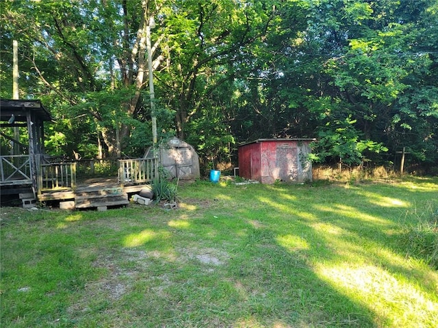 view of yard featuring a deck and a storage shed