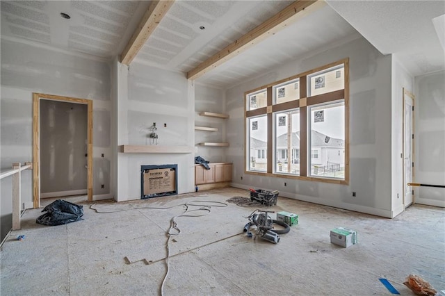 unfurnished living room featuring beamed ceiling