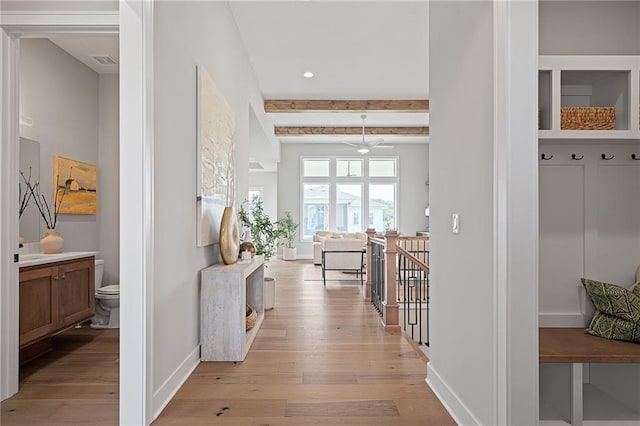 mudroom featuring beamed ceiling and light wood-type flooring