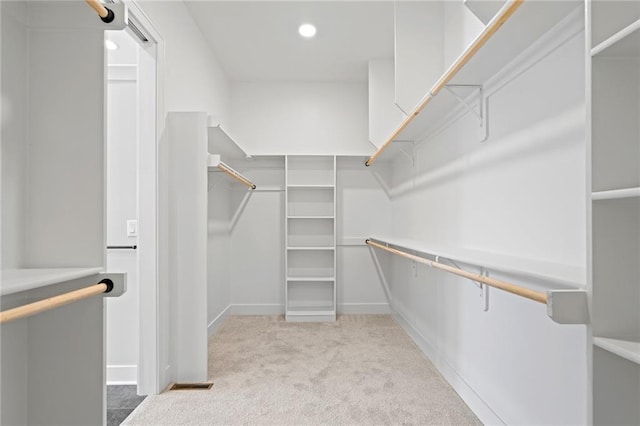 walk in closet featuring light colored carpet