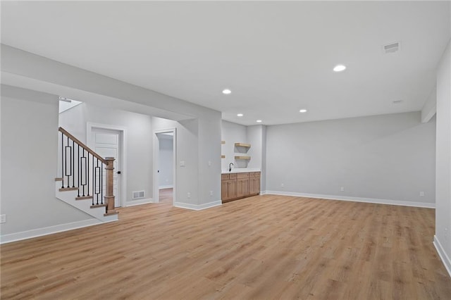 unfurnished living room with light hardwood / wood-style flooring and sink