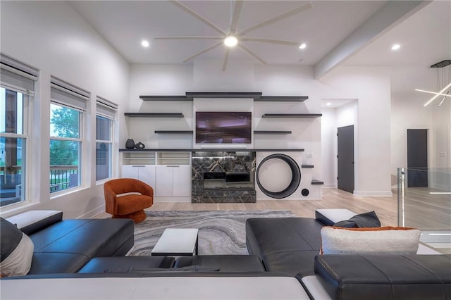 living room with beamed ceiling, a fireplace, and light hardwood / wood-style flooring