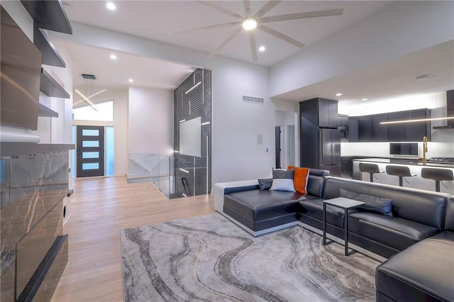 living room with a towering ceiling and light wood-type flooring