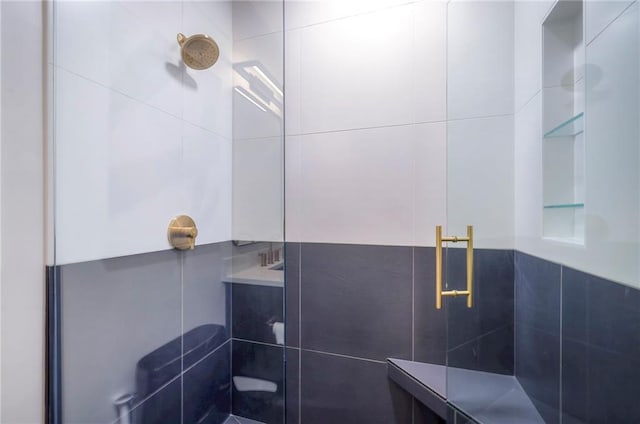 bathroom featuring an enclosed shower and tile walls