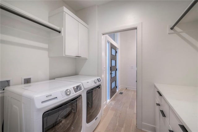 laundry room with cabinets, separate washer and dryer, and light wood-type flooring