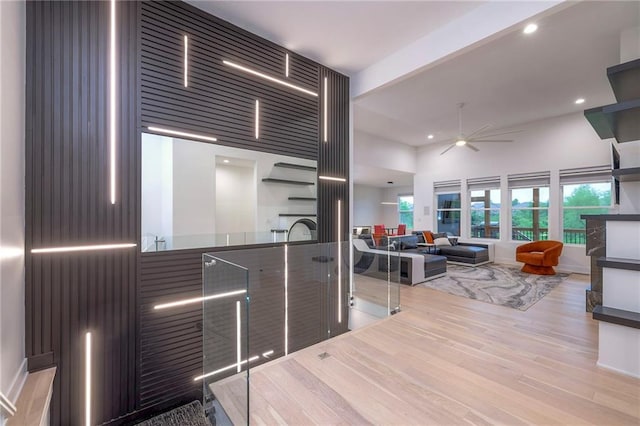 kitchen featuring ceiling fan, light hardwood / wood-style flooring, and a high ceiling