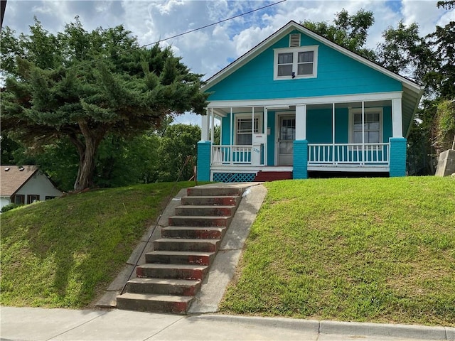 bungalow-style home with a porch and a front lawn