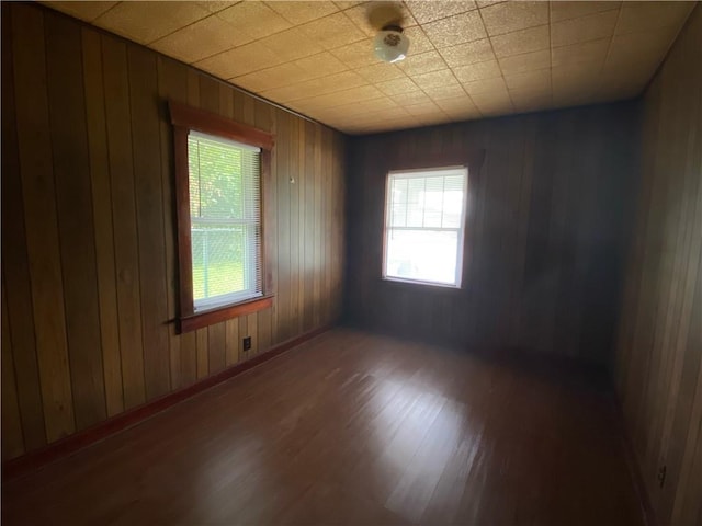 spare room with wooden walls and hardwood / wood-style flooring