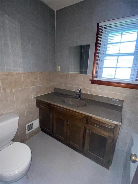 bathroom with tile walls, backsplash, toilet, and vanity