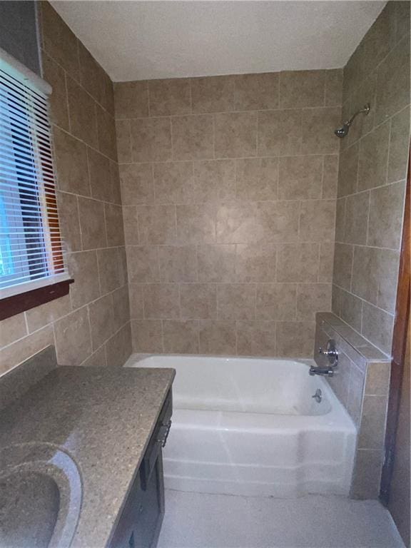 bathroom with tile walls, tiled shower / bath, vanity, and a textured ceiling