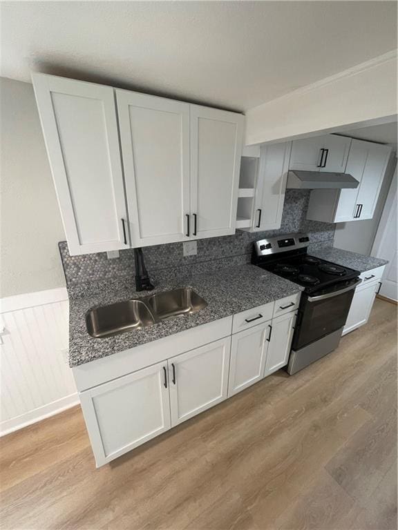 kitchen featuring light hardwood / wood-style flooring, white cabinets, sink, backsplash, and stainless steel range with electric stovetop