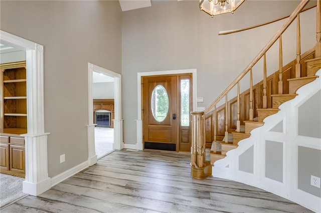 12815 NW 145th St, Platte City, MO 64079 - entryway featuring baseboards, stairs, a towering ceiling, wood finished floors, and an inviting chandelier