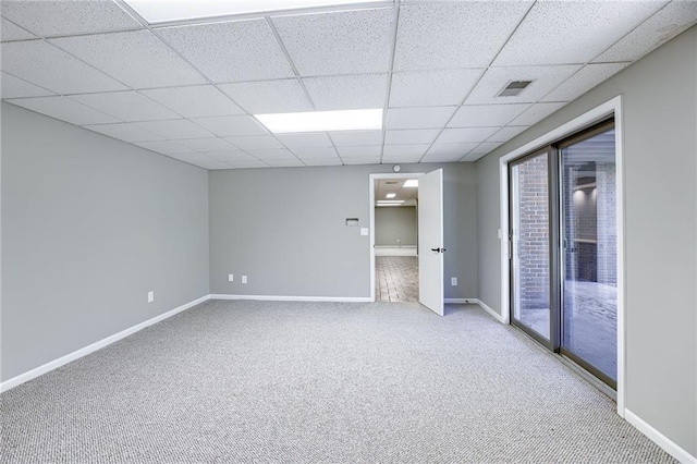 empty room featuring a drop ceiling and carpet floors