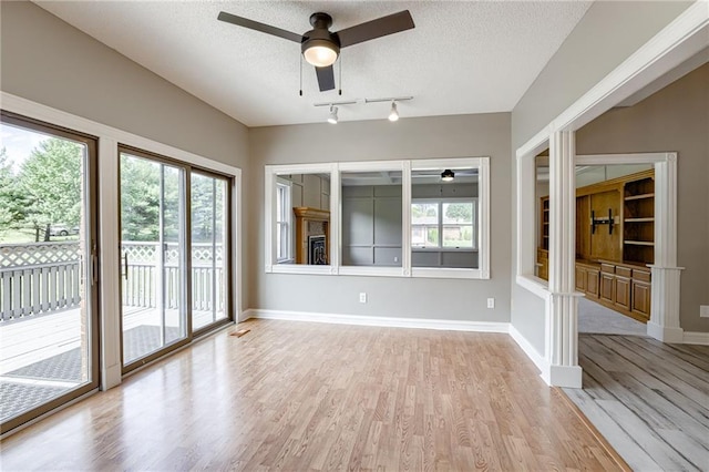 interior space featuring a textured ceiling, light hardwood / wood-style floors, and ceiling fan