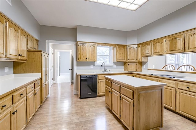 kitchen featuring a center island, sink, black dishwasher, and light hardwood / wood-style flooring