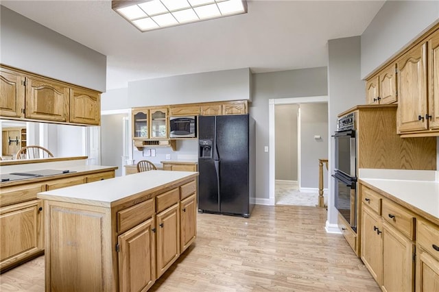 kitchen featuring light hardwood / wood-style flooring, a kitchen island, and black appliances